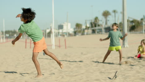 Slow-motion-of-happy-kids-perfecting-football-tricks-on-seashore